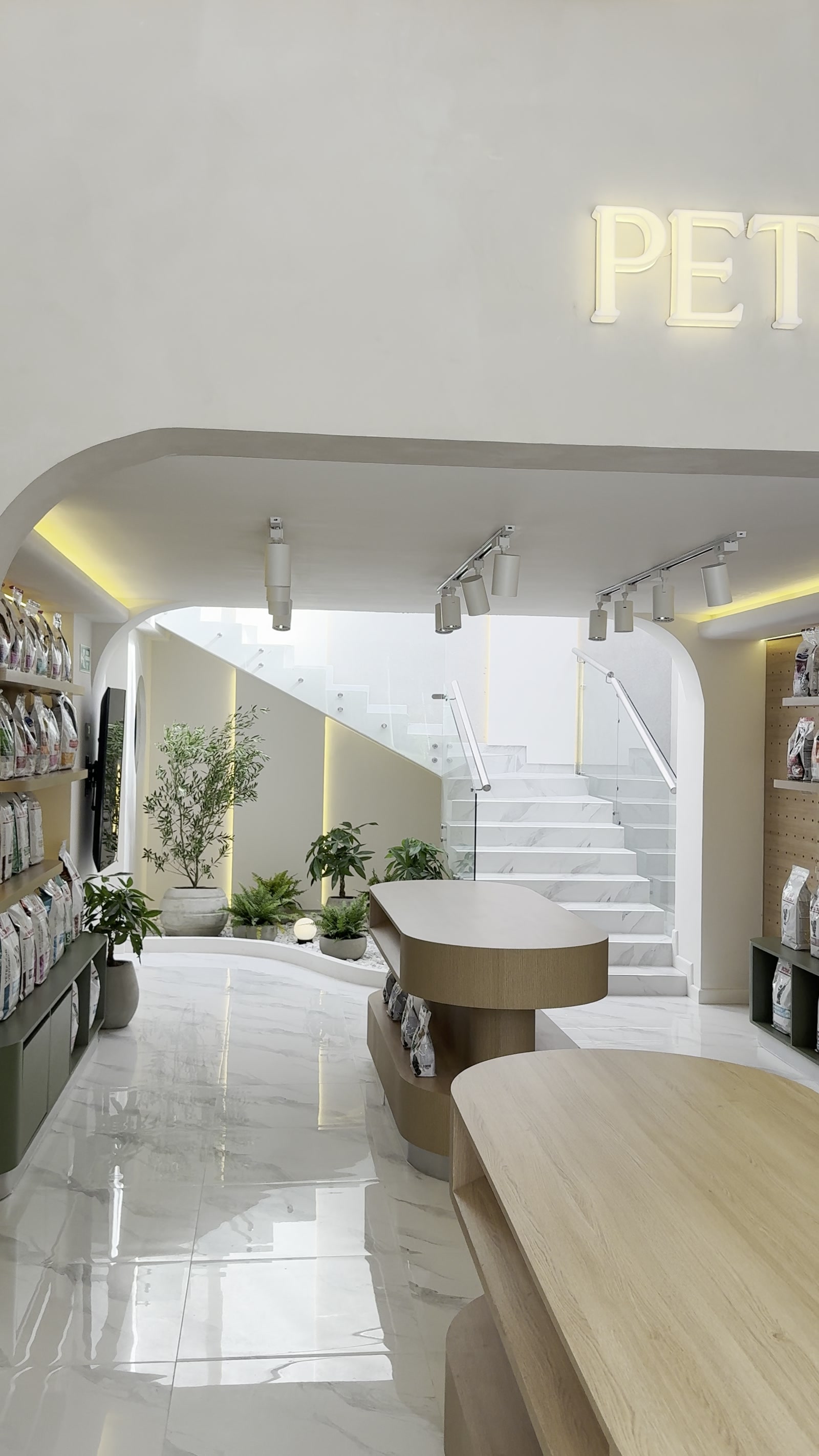 Pasillo de recepción de MÜVA by VetHelps, con el arco, el jardín interior y la escalera de mármol